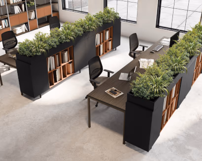 Open space con scrivanie e divisori verdi per comfort visivo