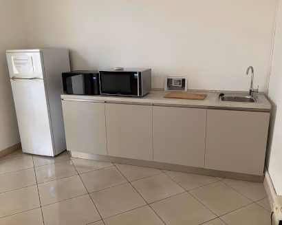 Cucina ufficio attrezzata per area break con frigorifero e microonde