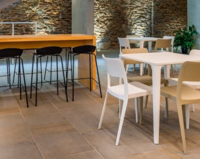 Zona ristoro ufficio con tavoli, sedie e bancone con sgabelli