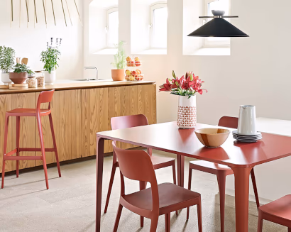 Area break con tavolo e sedute colorate vicino a cucina ufficio moderna