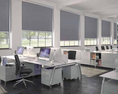 Ufficio open space con tende a rullo per comfort visivo e schermatura solare